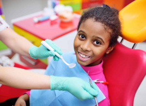 Child smiling during a pediatric dental checkup.